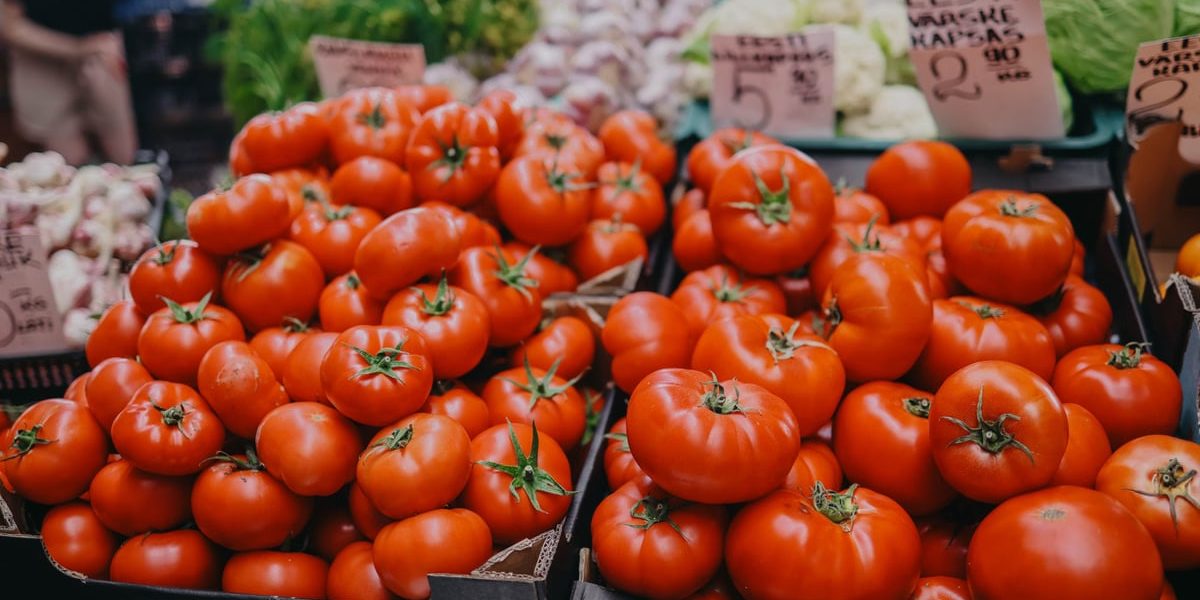 Vibrant red tomatoes on display at an outdoor market, an inviting scene for fresh produce lovers.