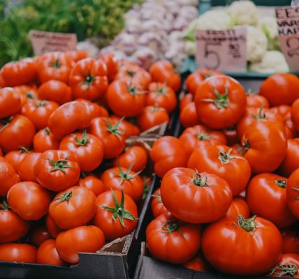 Vibrant red tomatoes on display at an outdoor market, an inviting scene for fresh produce lovers.
